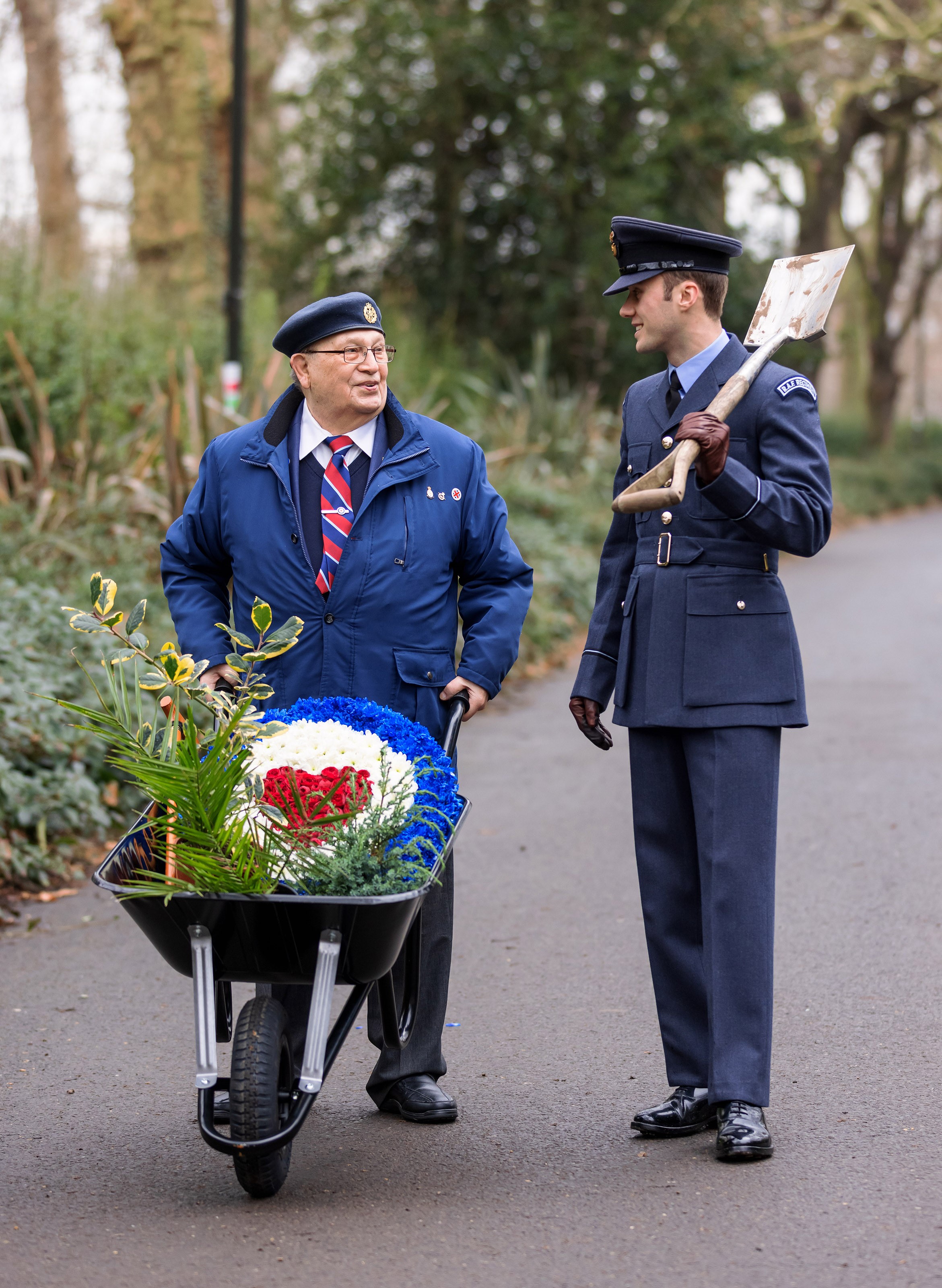 Veteran and Personnel talk with wheelbarrow, spade, and plants.Veteran and Personnel talk with wheelbarrow, spade, and plants.